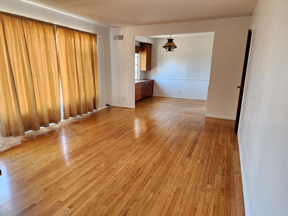 Large and bright living room and dining area outside of kitchen.