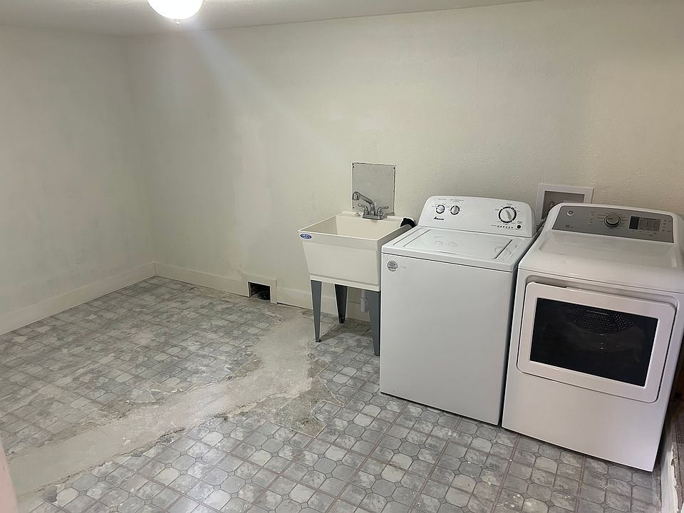 The in-unit laundry room with plenty of additional storage and a utility sink.
