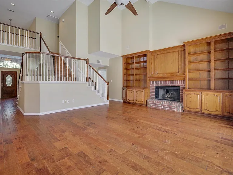Soaring ceilings, wood flooring, built-ins, fireplace and an abundance of light define this expansive living space