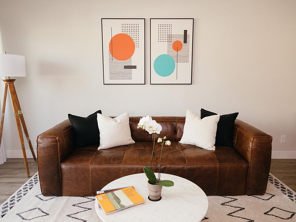 Spacious living room with a leather couch and marble coffee table.