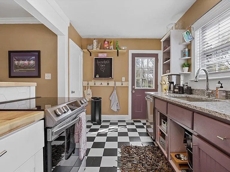 Kitchen at Hunsucker's was completely remodeled in 2023 and features stainless appliances and checkerboard tile floor all within walking distance of Downtown and Cone Hospital