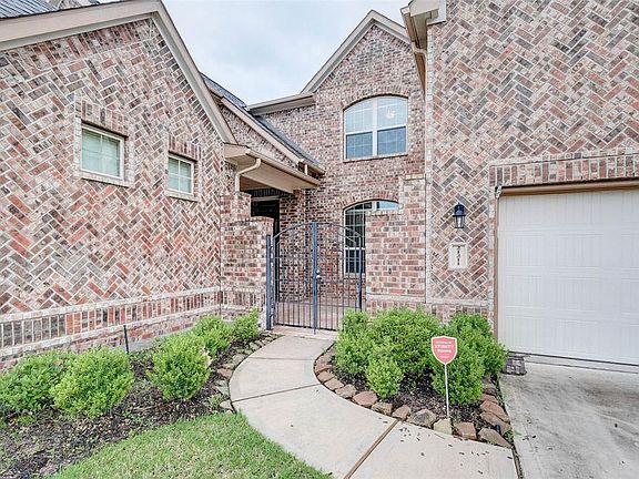 A close up of the entrance to the home with wrought iron gate leading through to the charming front courtyard.
