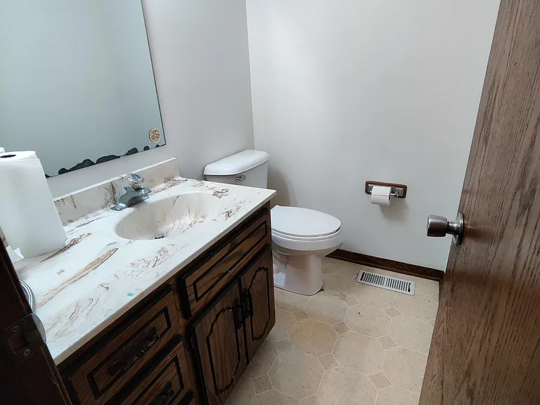 Half bath off of the kitchen, brand new toilet.