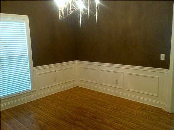 Ceramic tile entry foyer flows into new laminate flooring in the formal dining and family room in this open plan.