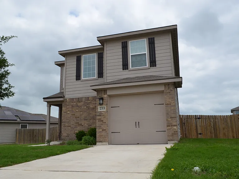 Charming two-story single-family home featuring a private driveway, attached garage, and well-maintained exterior.