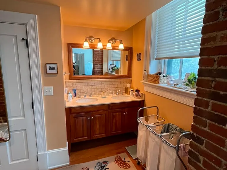 Lovely double sink set in marble in front of second Master suite window. Cherry cabinets.