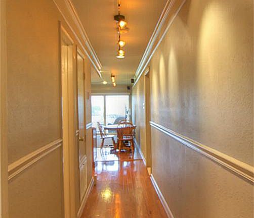 Beautiful hallway with double doors and hardwood flooring.
