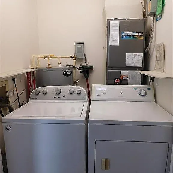 Across from guest bath is laundry closet that also contains AC and water heater unit. The washing machine is new.