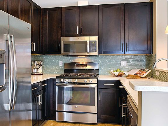 Kitchens feature stainless steel appliances, quartz countertops, and espresso cabinets