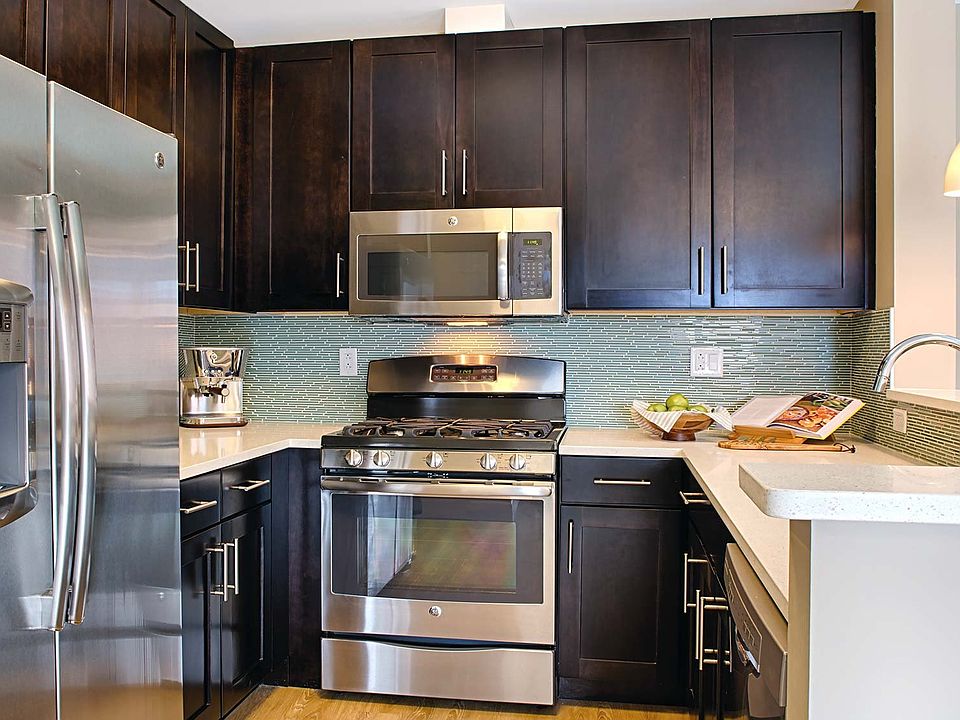 Kitchens feature stainless steel appliances, quartz countertops, and espresso cabinets