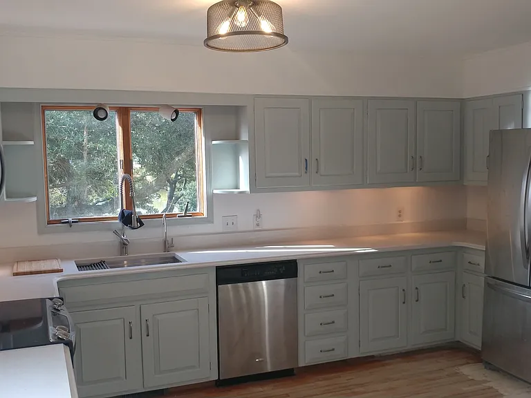 Kitchen with new quartz countertops, large pantry, stainless appliances, trash compactor, and live-edge bar.