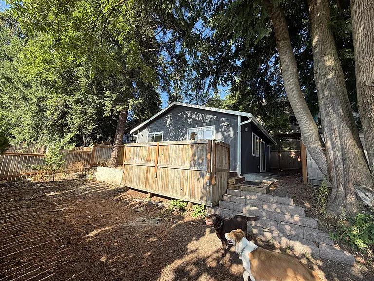 front exterior of house. stairs lead up to deck and front entrance