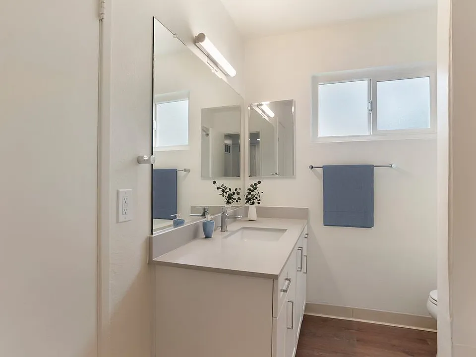 Renovated Package I bath with white cabinetry, beige granite countertops, and hard surface flooring