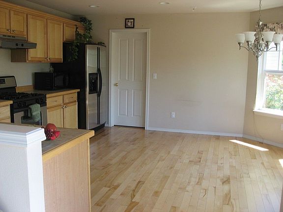 Kitchen - Tile countertops, stainless steel appliances and hardwood floors