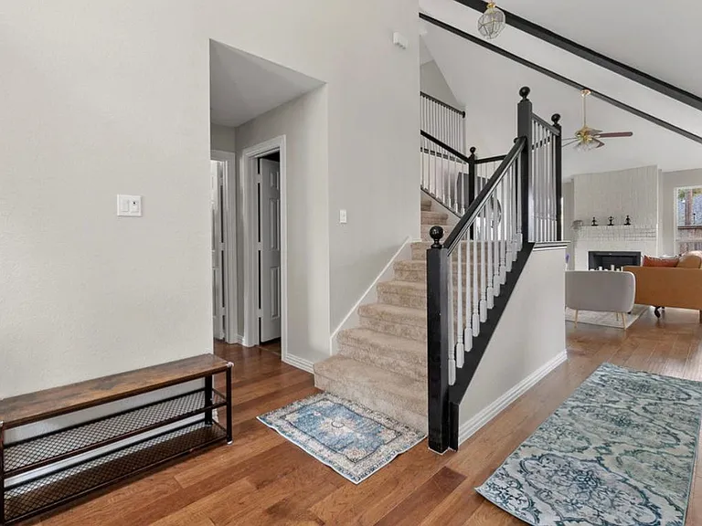 Foyer with a bench to store and wear shoes. To the left is a hallway leading to half bath, coat closet, and master suite (bedroom #1). To the right is bedroom #2 with a king bed.