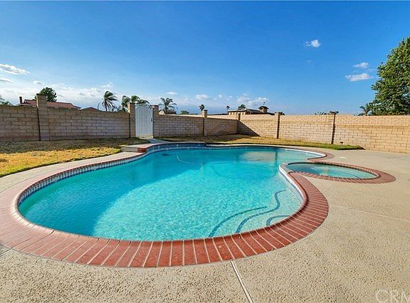 Pool and jacuzzi in backyard.