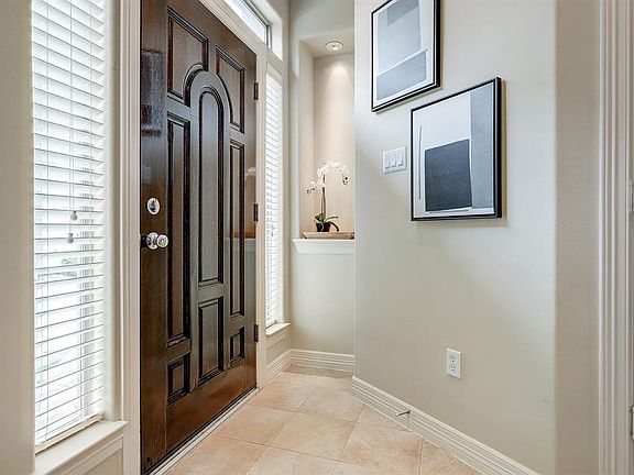 Lovely hardwood front door opens into the tiled entry hall complete with art niche and multiple windows.