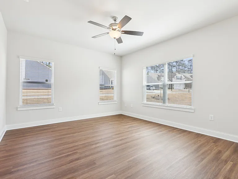 Bedroom with wood floors and a ceiling fan.
