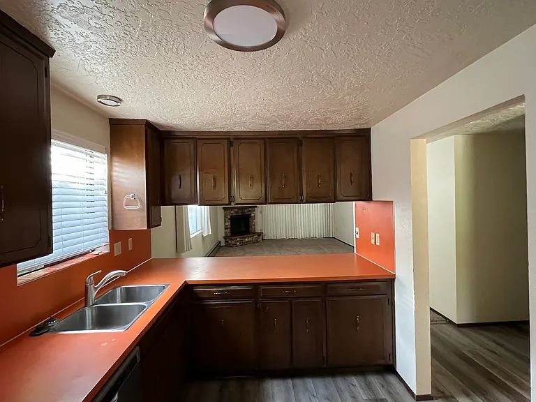 Updated plank flooring and LED lighting. 70's orange vibe, original counters and wood cupboards.