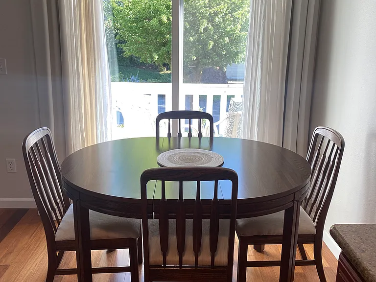 View from kitchen through dining area to your cozy private deck with storage. Dining table & chairs are included if you want them.