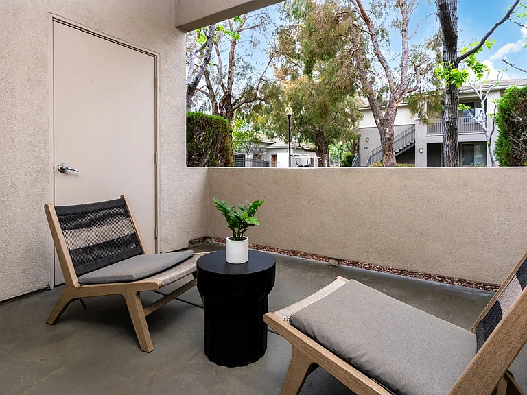 Apartment Balcony with Modern Chairs and Peaceful Courtyard Views
