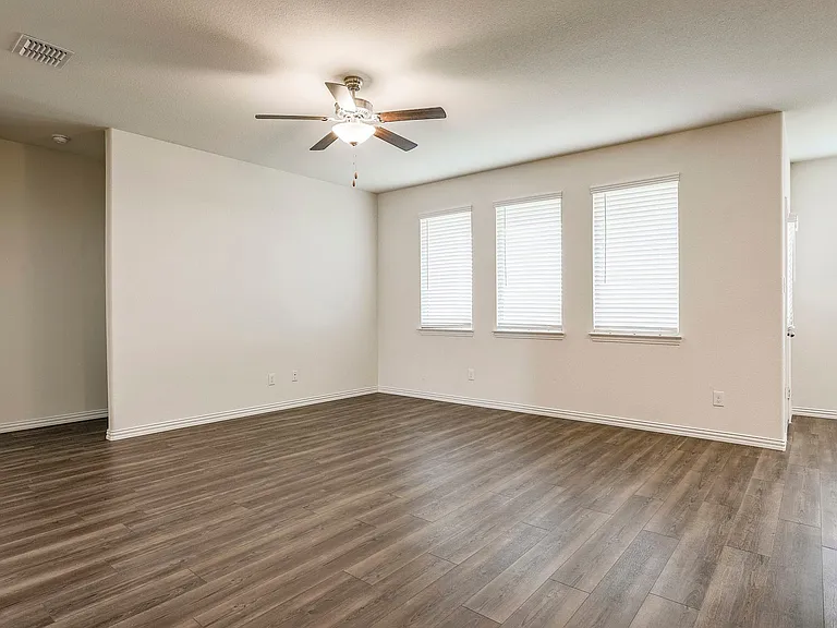 Unfurnished room with dark wood-type flooring and ceiling fan