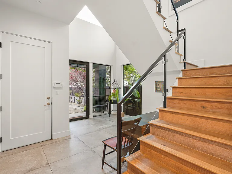 A view of the foyer, staircase and door to the garage