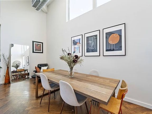 Large open dining area attached to living room and kitchen with two story ceiling and tons of natural light.
