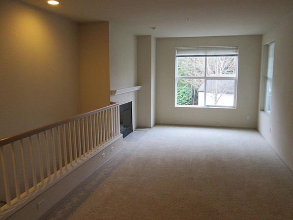 Living room with wood burning fire place and large windows.