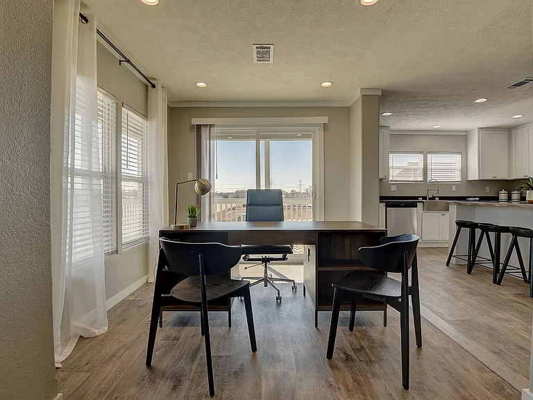 Light-filled flex space with scenic views, perfect for a home office or dining area, seamlessly connected to the open-concept kitchen for modern, functional living.