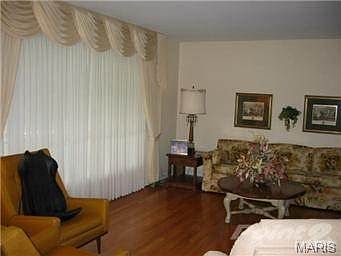 Large picture windows and wood flooring in living room.