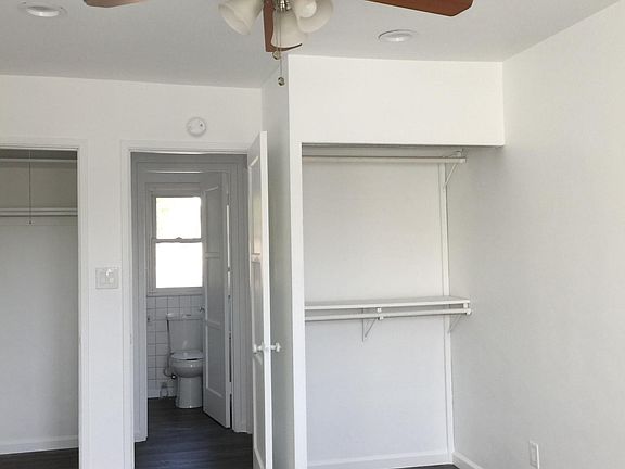 Clean bedroom with ceiling fan and closet.