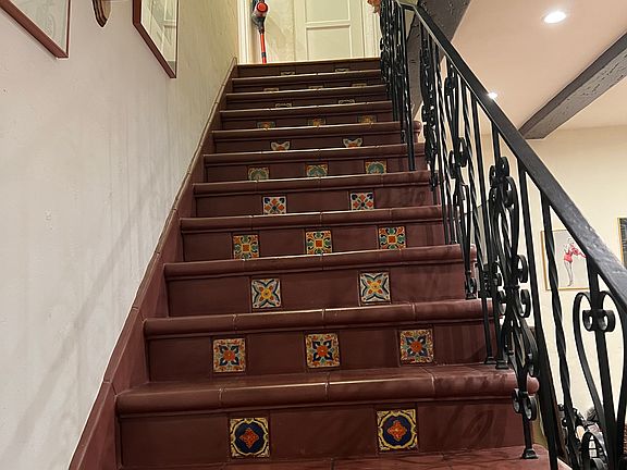 spanish stairs leading from living room to upstairs, both bedrooms are at the rop of the stairs immediately to the right and left and straight ahead is a hallway closet
