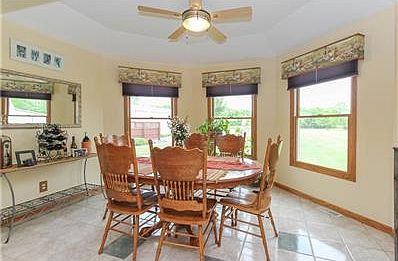 Dining Room with Tile Flooring & Wall of Windows overlooking backyard.