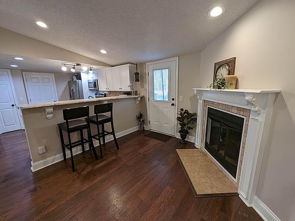 Close up of fireplace, backdoor & kitchen