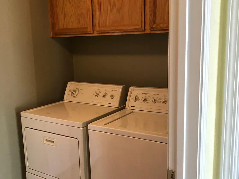 Laundry with dryer (left) and washer (right) with cabinetry