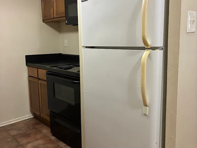 View of kitchen right side. A microwave oven is over the stove.