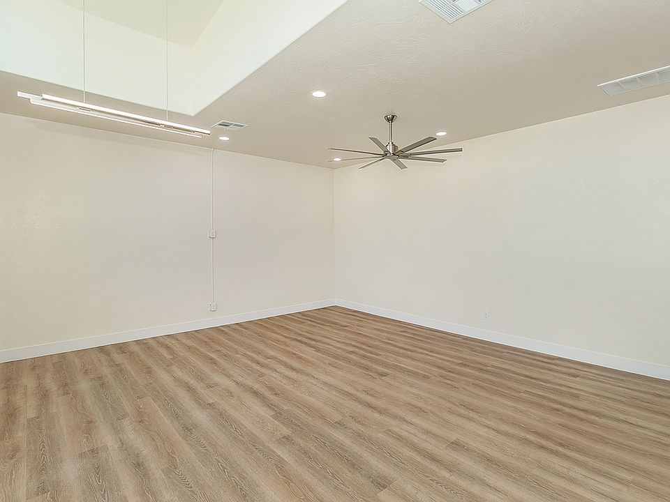 Large High Vaulted Ceiling with Custom Fan, Amazing Large Windows, Luxury Vinyl Plank Flooring, And Automatic Roll Down Shades.
