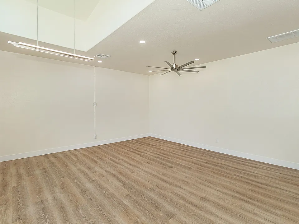 Large High Vaulted Ceiling with Custom Fan, Amazing Large Windows, Luxury Vinyl Plank Flooring, And Automatic Roll Down Shades.