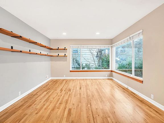 Living room with corner window and wrap around floating shelves