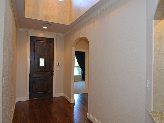 Wide open hallways and vaulted ceiling in entrance with beautiful rich wood floors