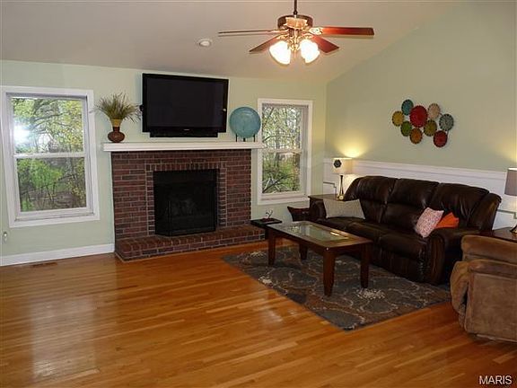 Vaulted great room with gas fireplace, plant shelves, hardwood floors-overlooks beautiful back yard.