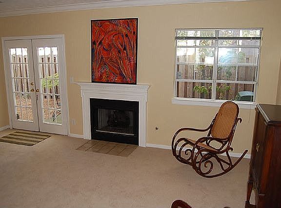 Large living room has a fireplace and french doors to the backyard