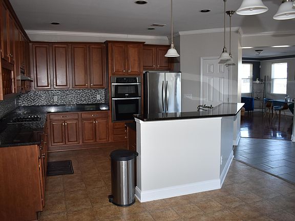Large kitchen with gas stove top, storage, and granite counter tops