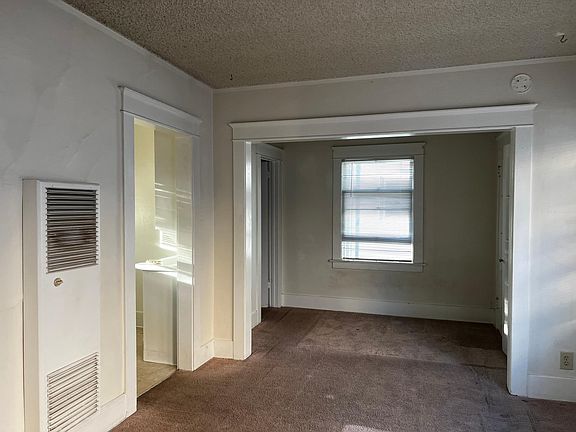 living and sleeping alcove shown when vacant.Photo show sleeping alcove from the main living area.To the left is the kitchen with builtins and interesting cabinetry partially in sight. The kitchen has stove and refrigerator.