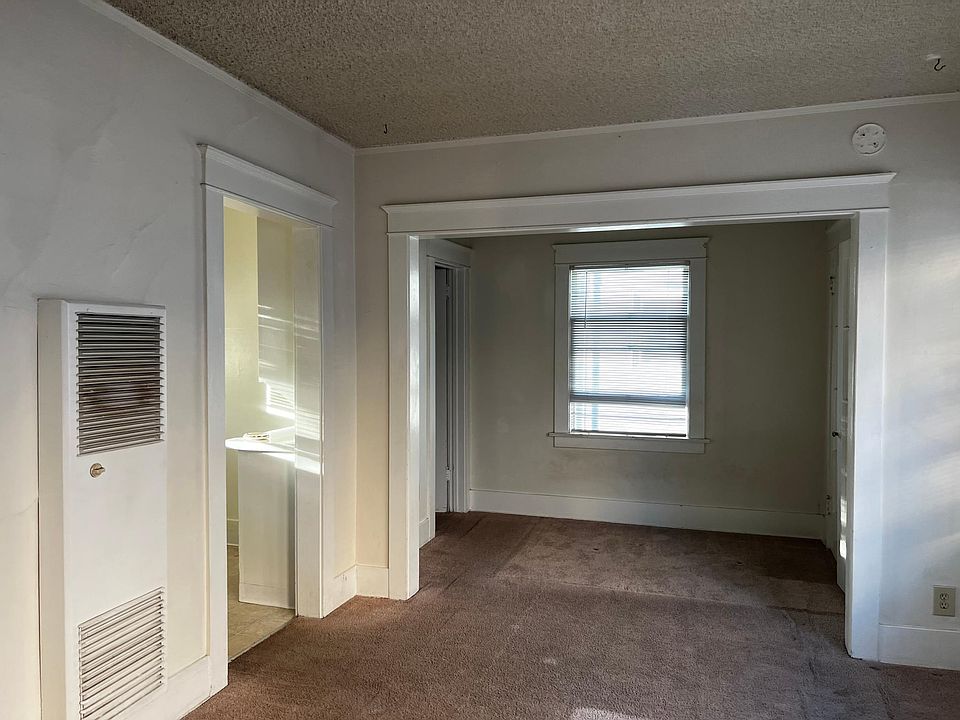 living and sleeping alcove shown when vacant.Photo show sleeping alcove from the main living area.To the left is the kitchen with builtins and interesting cabinetry partially in sight. The kitchen has stove and refrigerator.