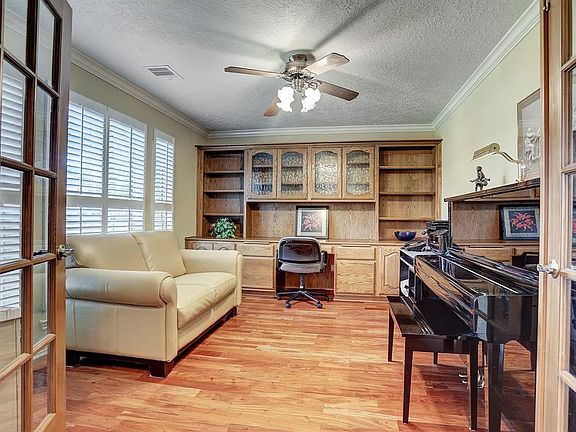 This amazing private study is separated from the rest of the home by French doors. An entire wall is devoted to handsome wood built-in cabinets and open shelving with a desk. Large windows with plantation shutters fill this beautiful space with incre