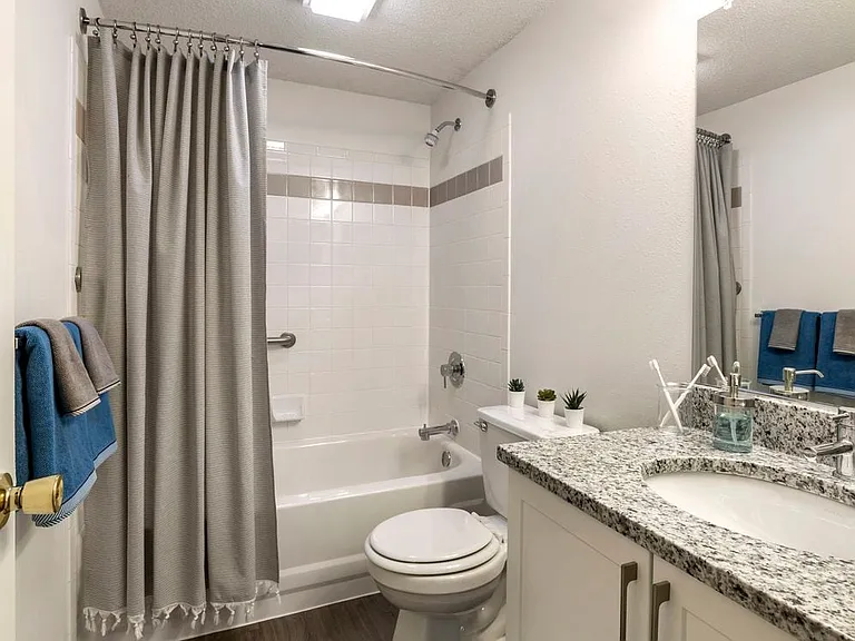 Renovated Package II bath with white cabinetry, quartz countertops, and hard surface flooring