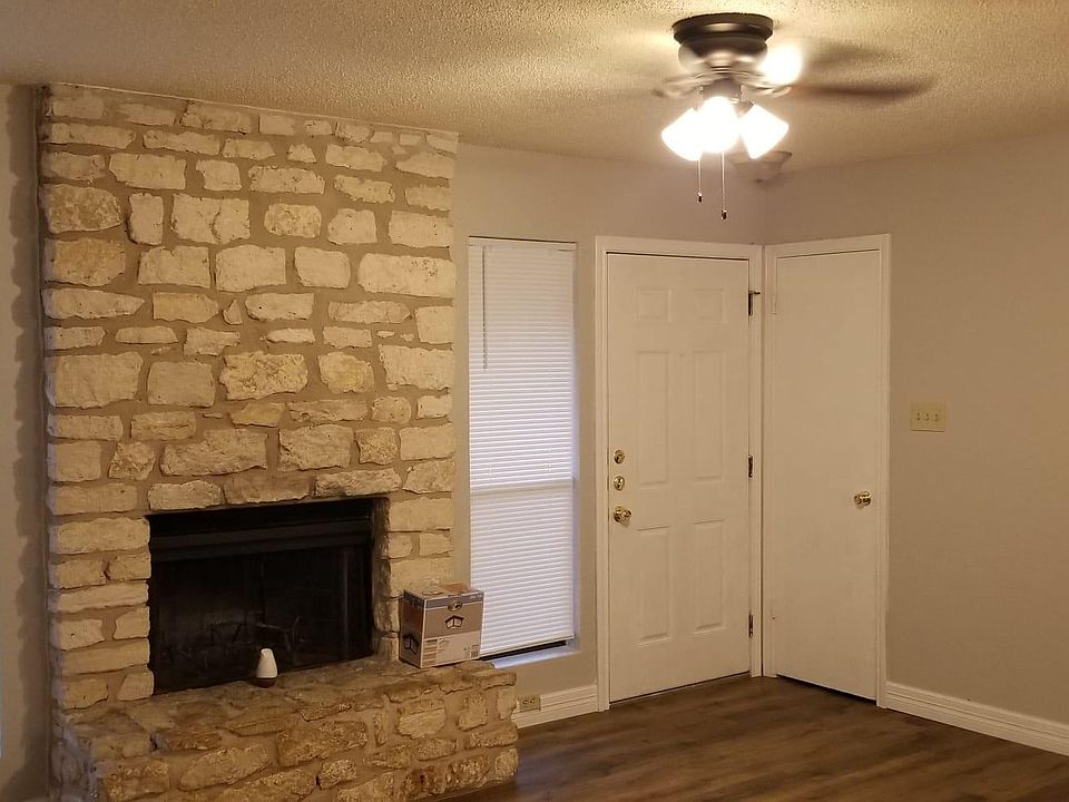 Living room with Fireplace, new fans, blinds, and brand new flooring.