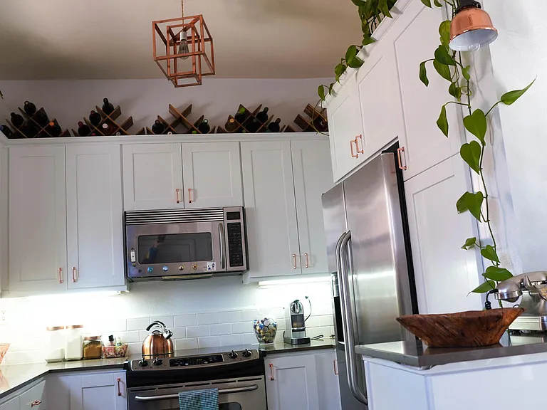 kitchen with modern copper lighting, stainless steel appliances (microwave, fridge, oven/stove)